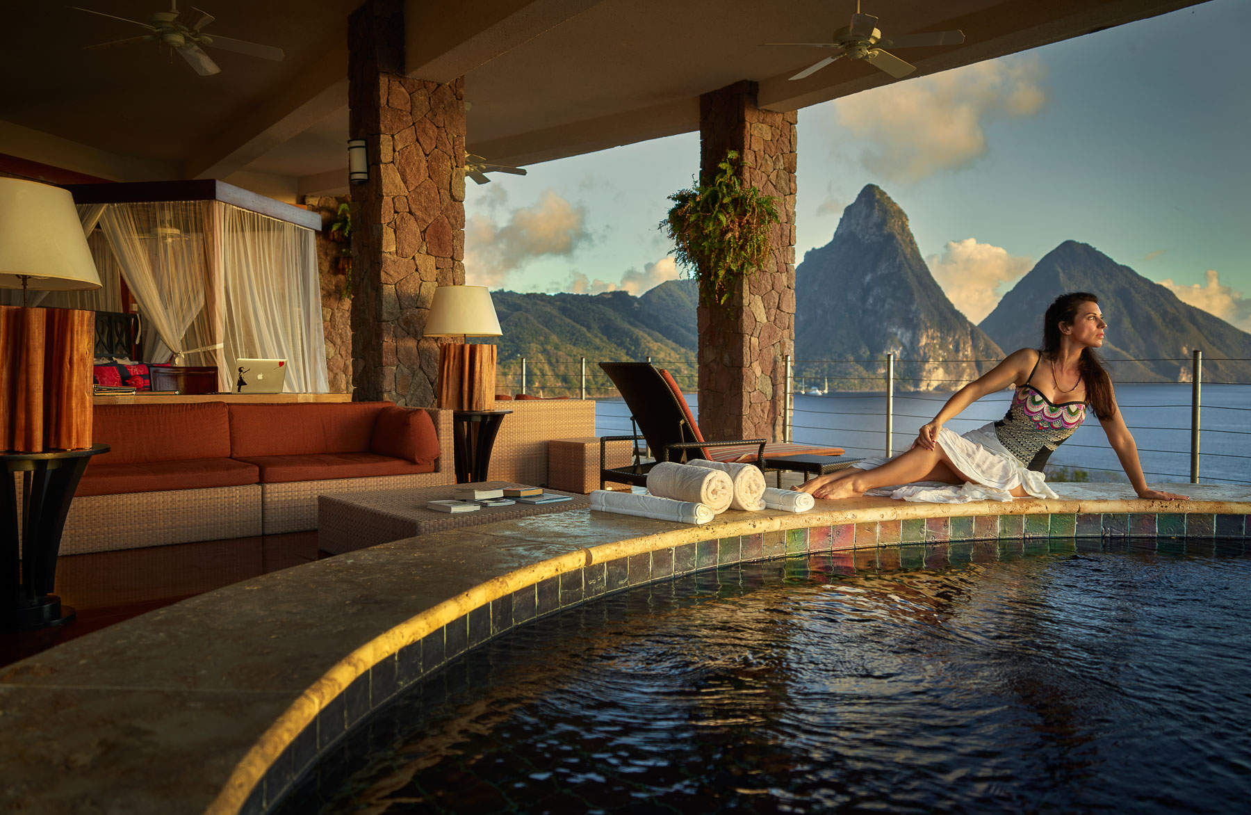 A woman next to the infinity pool in her luxury suite 