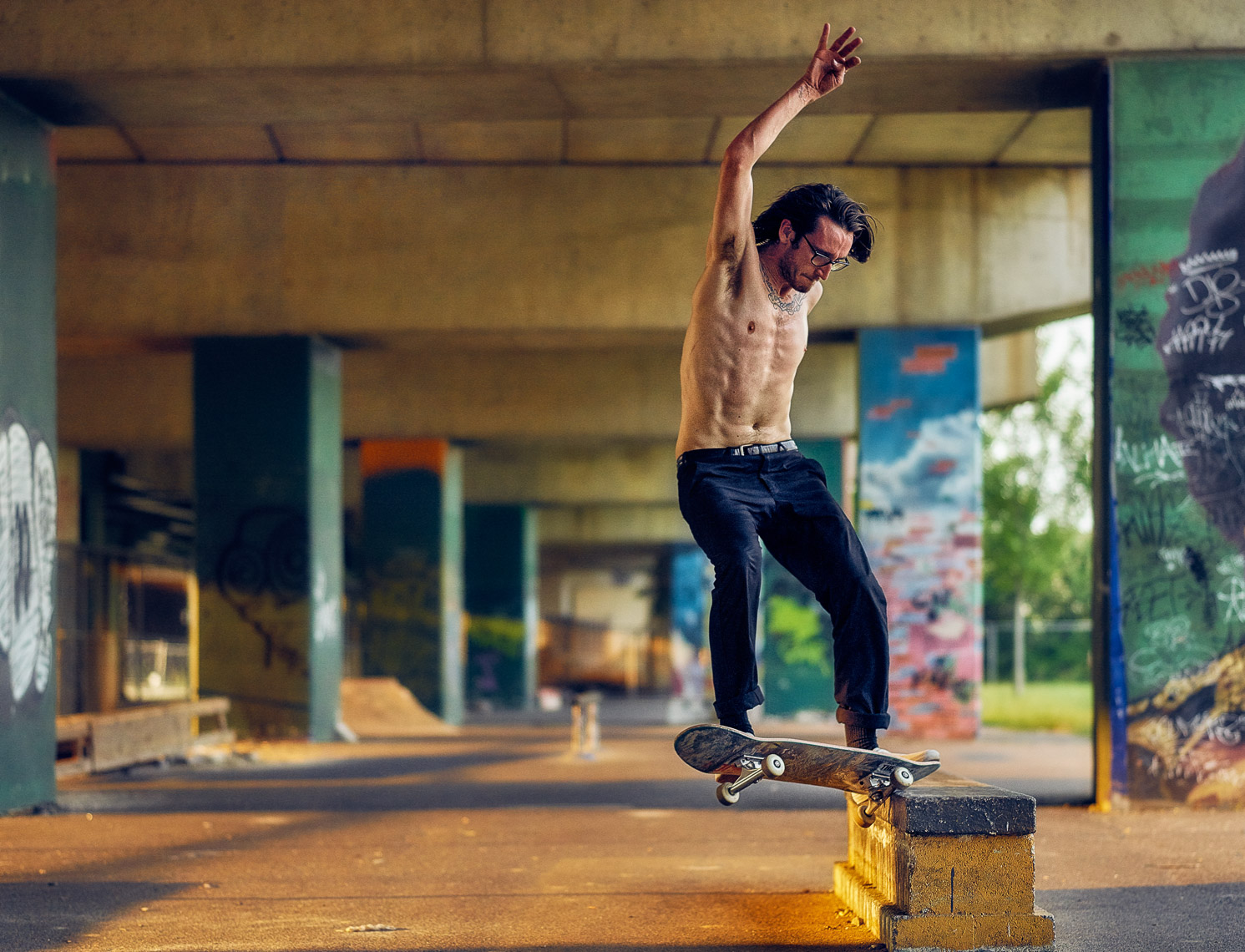 Kevin Steele - a skateboarder under an urban railroad bridge