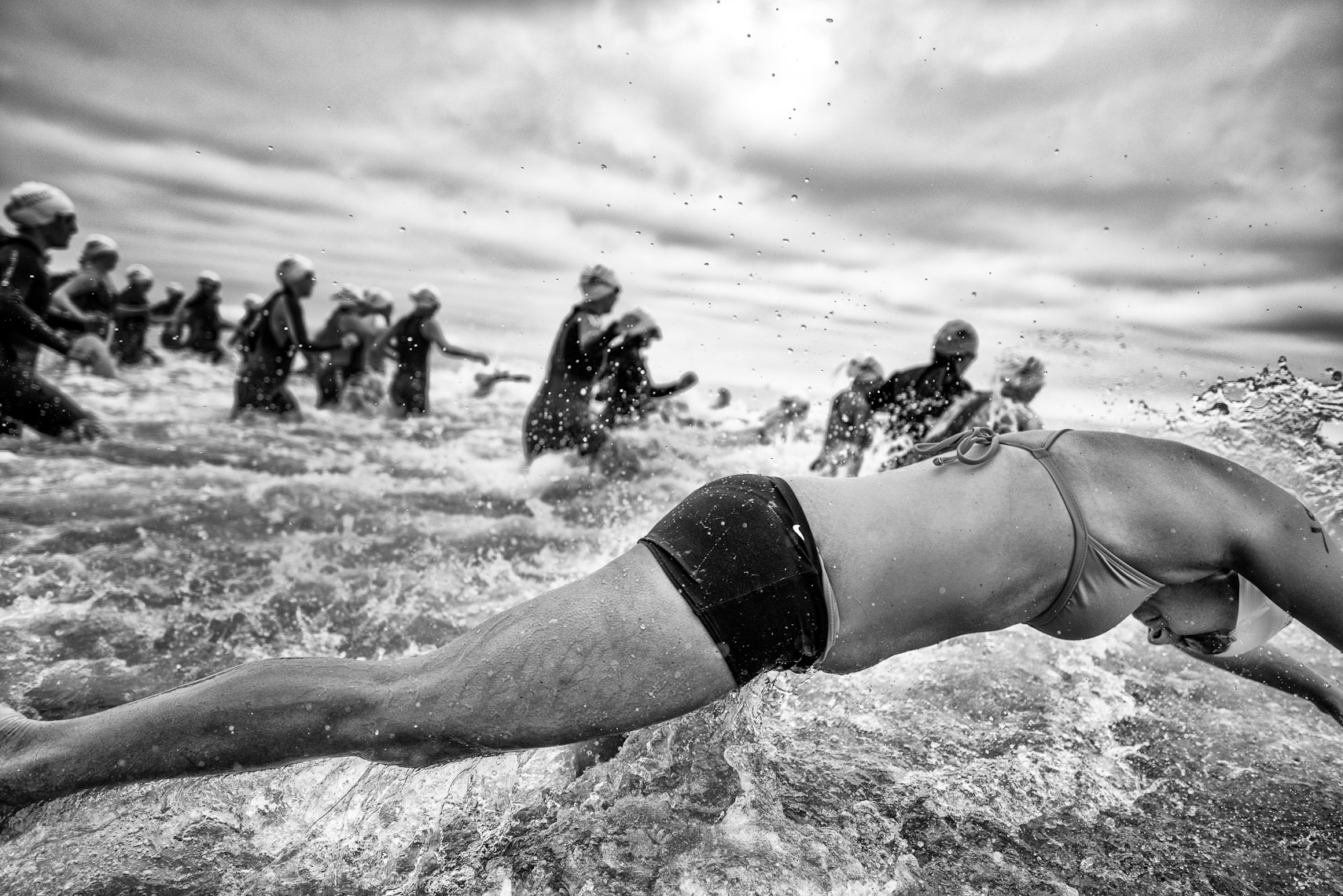 Kevin Steele - a woman dives into the ocean at a triathlon