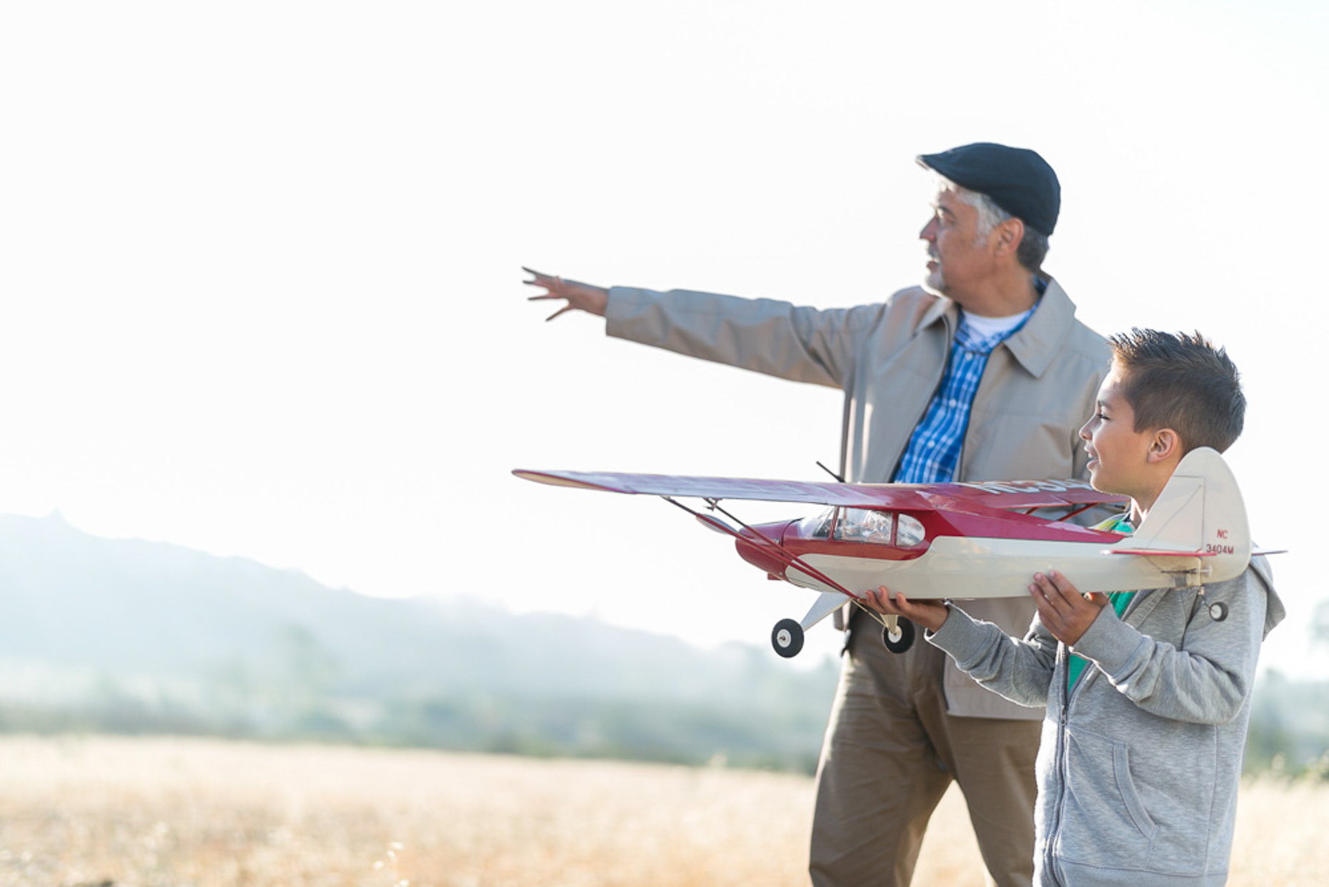 Kevin Steele - An elder man helps his grandson fly a model airplane 